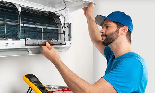 Bajrang Aircool Service technician servicing an AC unit